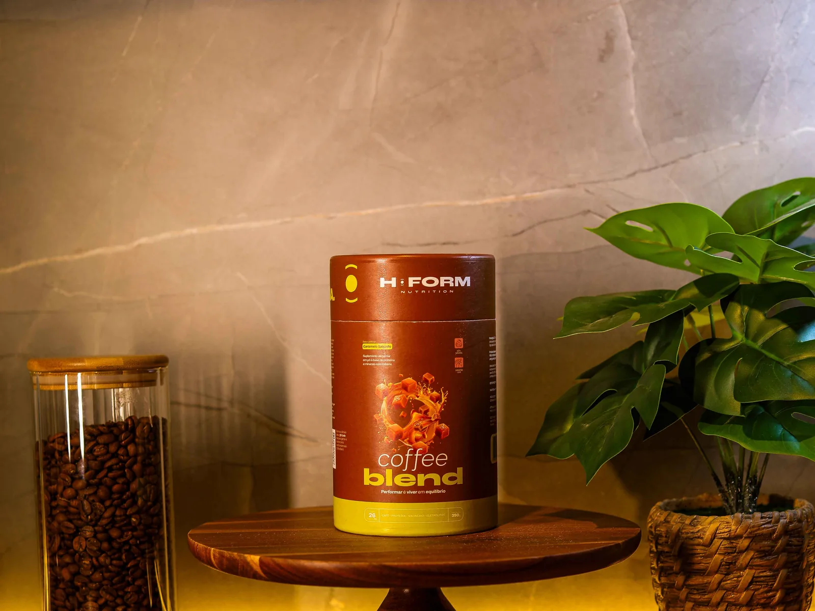 Pote de Coffee Blend sobre bancada de madeira, ao lado de um vidro com grãos de café